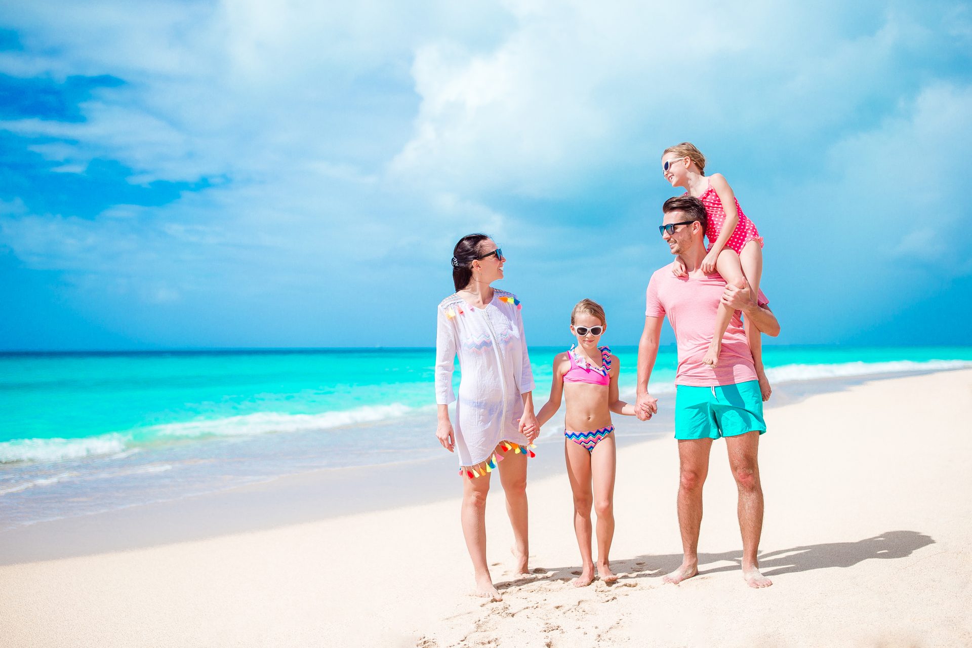 happy-beautiful-family-on-white-beach-L53EU9M